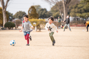 公園でサッカーをする子供